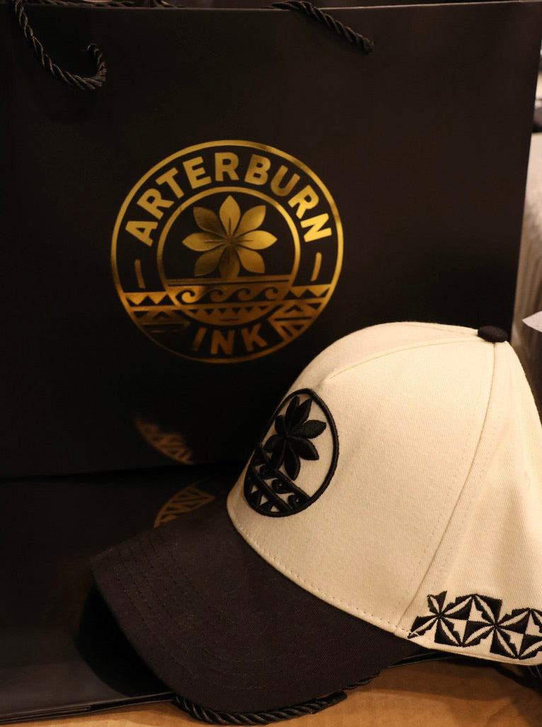 Cap with black and white design next to a branded black bag
