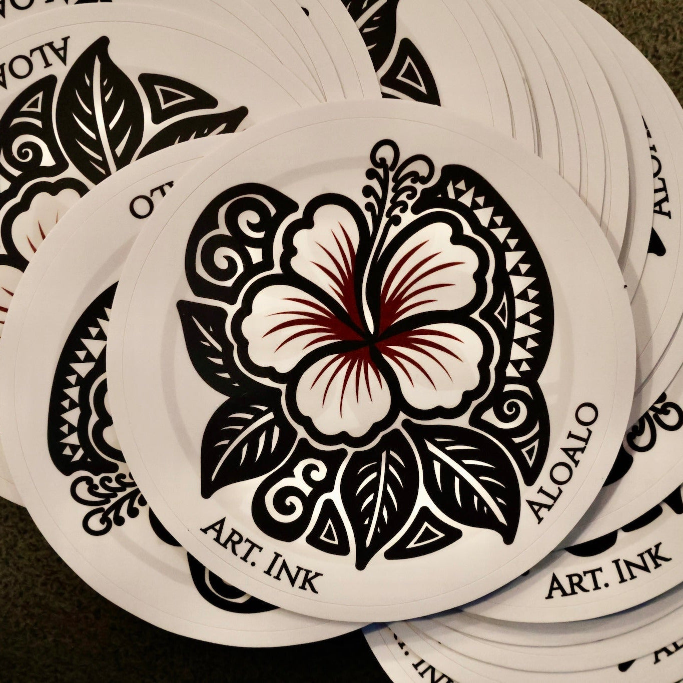 Stack of circular stickers with floral  design and 'Art Ink' branding.