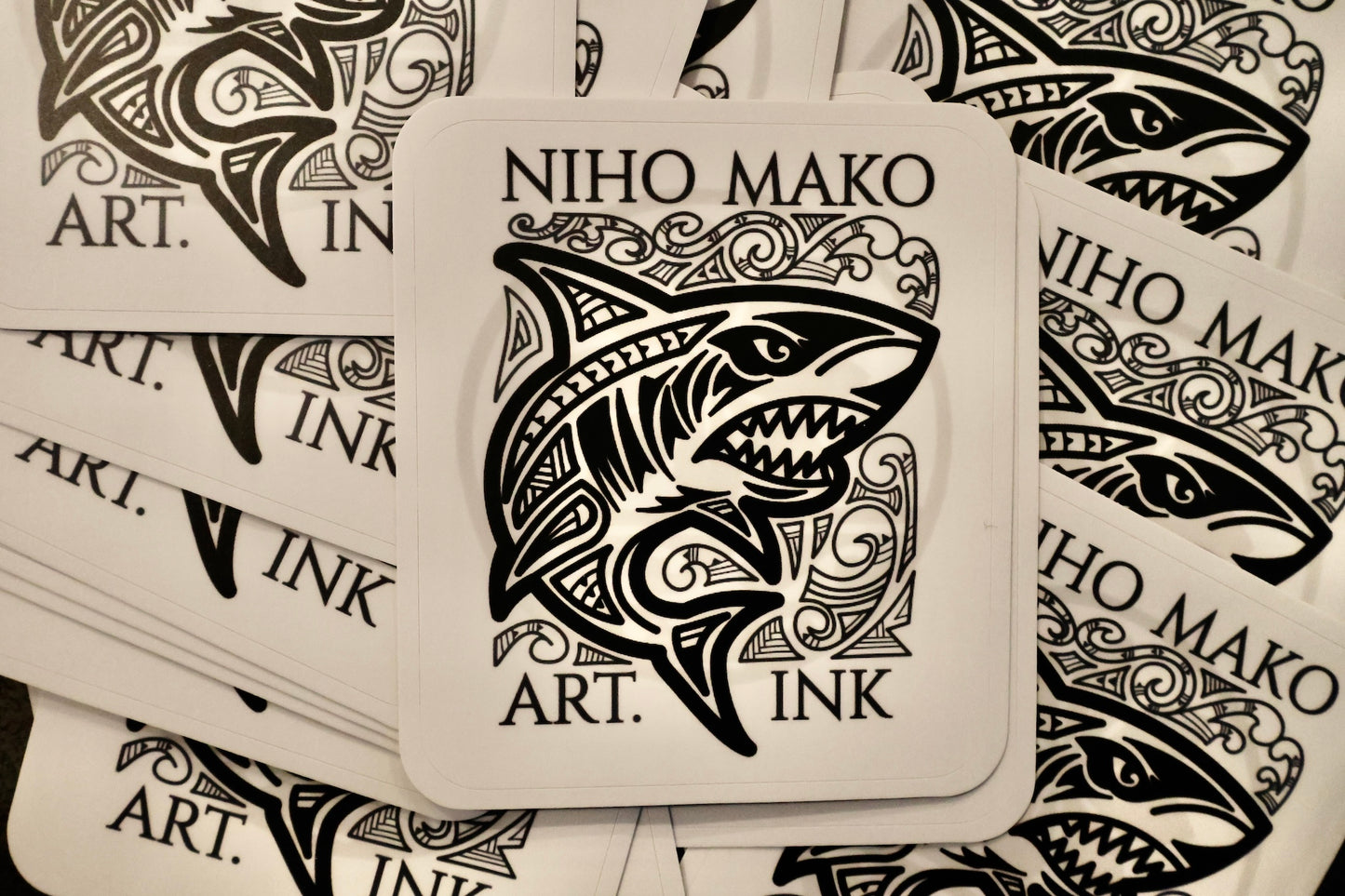 Sticker with shark design and 'NIHO MAKO ART. INK' text on a patterned background