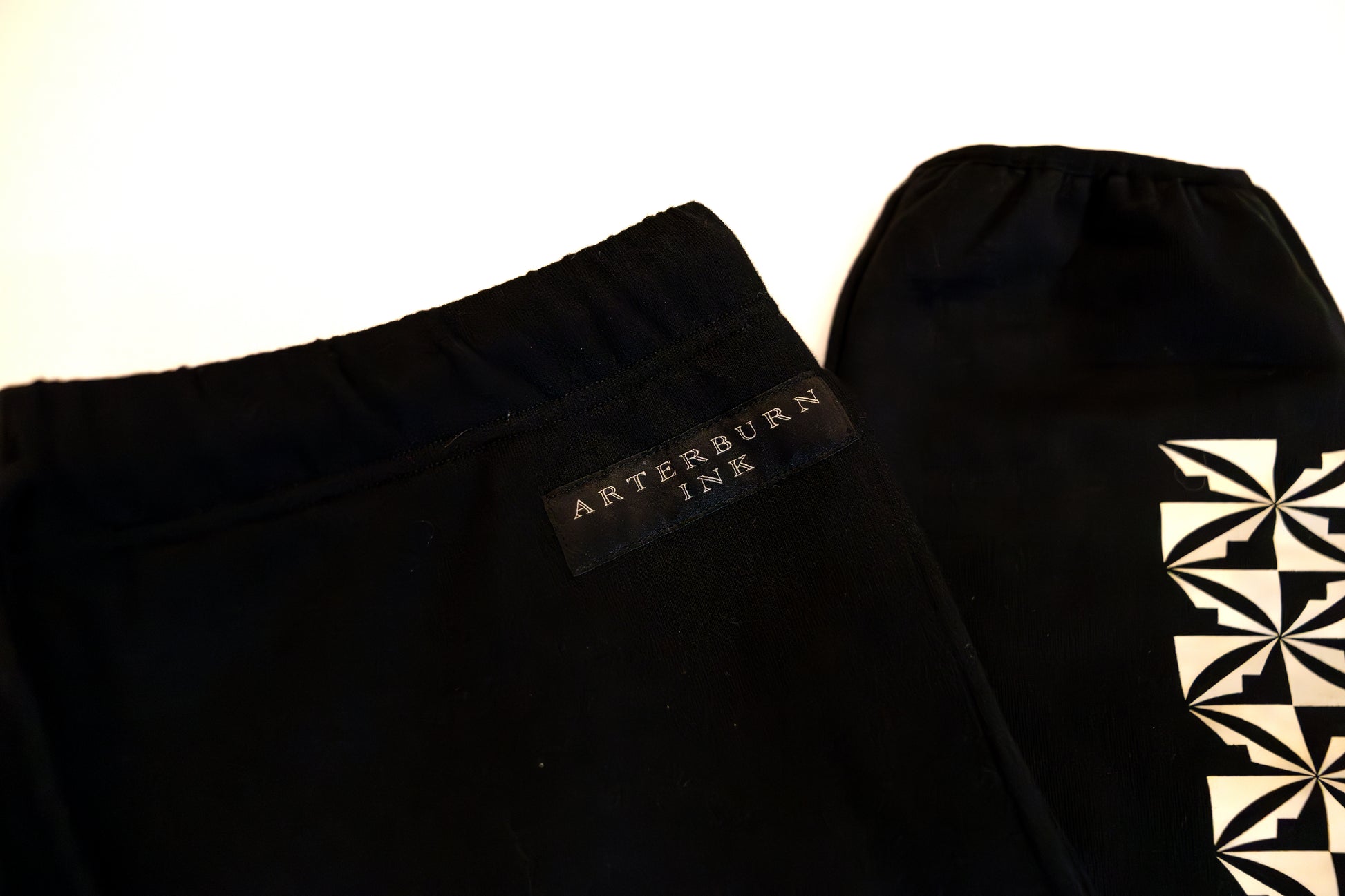 Black pants with a brand label on a white background