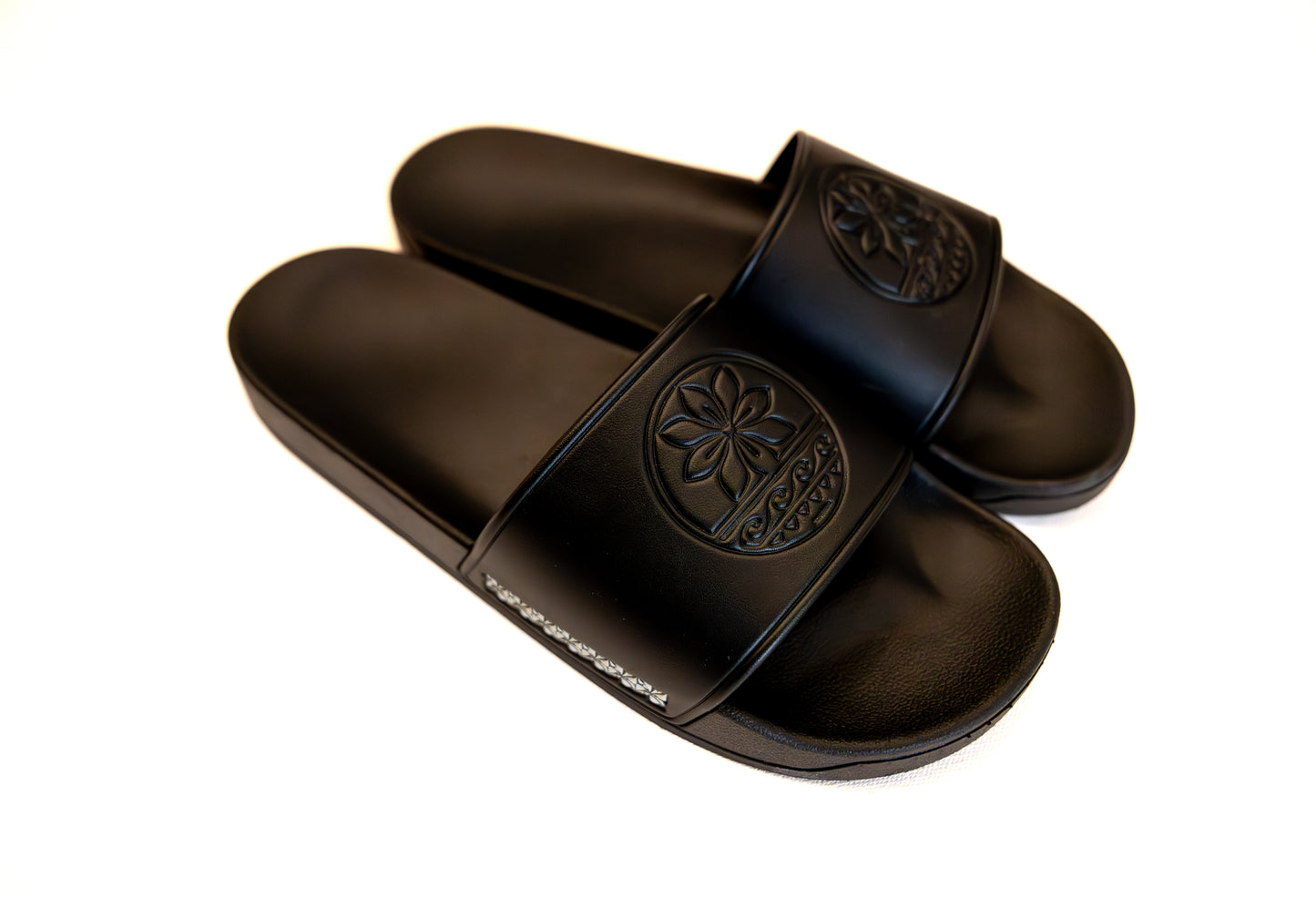 Pair of black slides with a brand logo on a white background