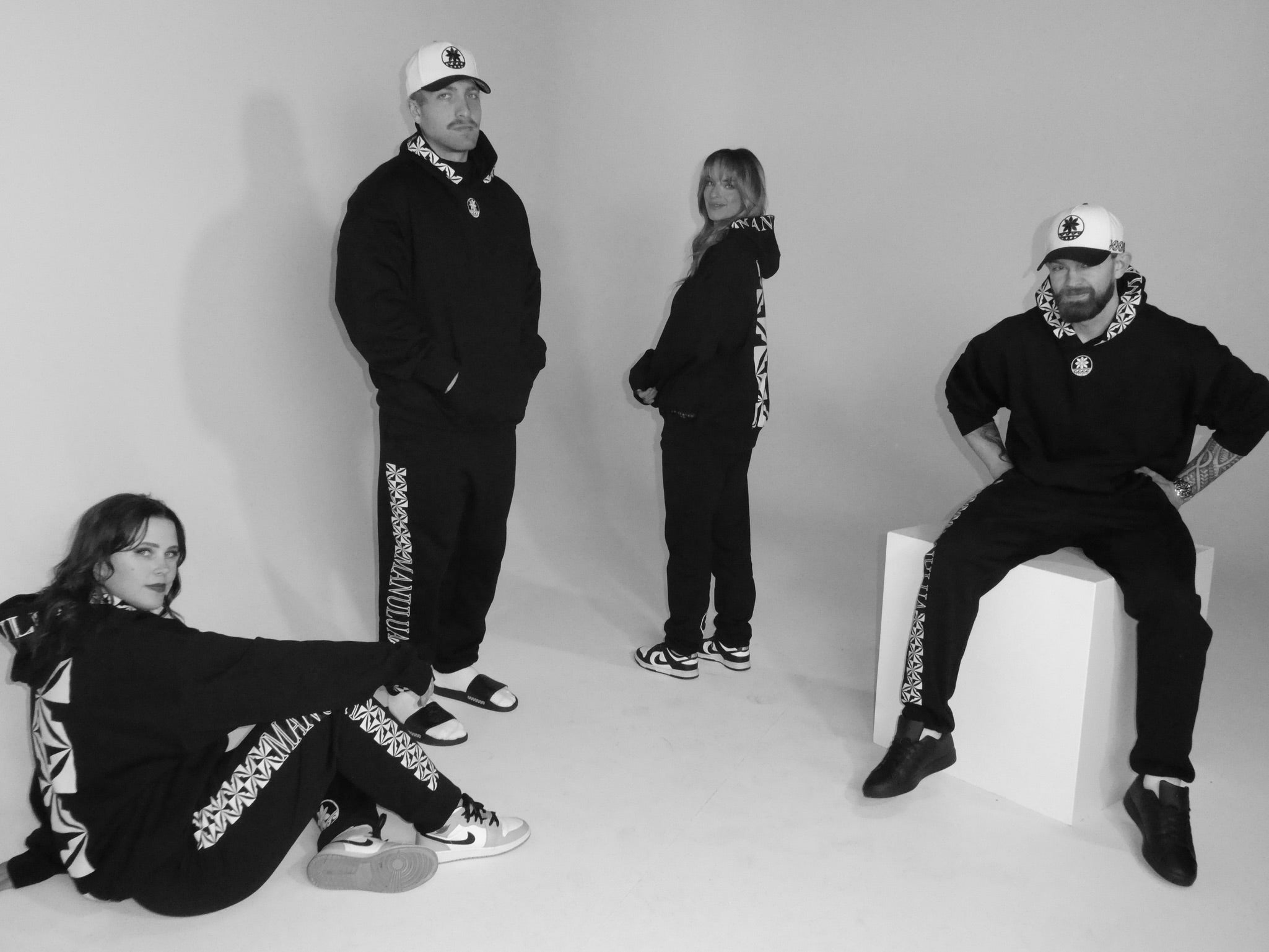 four people wearing manulua hoodies